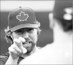  ?? — Photo by The Canadian Press ?? Toronto Blue Jays’ pitcher R.A. Dickey talks knucklebal­l with Jays’ catcher Josh Thole during the team’s spring training session in Dunedin, Fla., on Tuesday.