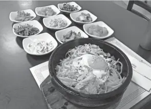  ?? GARY SEMAN JR./COLUMBUS DISPATCH ?? Stone pot bibimbap and banchan (petite sides) at Ming-ga Korean Restaurant