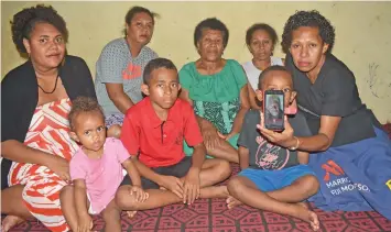  ?? Photo: Mereleki Nai ?? Mere Lewaravu holding the picture of her late father, Mikaele Sarosaro, with family members at Korociri in Nadi.