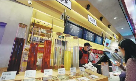  ?? LI ZHIHAO / FOR CHINA DAILY ?? A customer places an order at the nation’s leading herbal tea brand Wanglaoji’s offline drink shop in Guangzhou, Guangdong province.