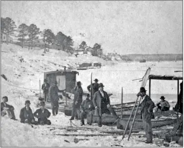  ?? (Special to the Democrat-Gazette) ?? Several men stand beside small boats at the edge of the frozen Arkansas River in Pulaski County during the winter of 1876.