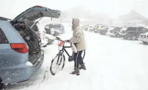  ?? JOURNAL SENTINEL FILES ?? A woman wheels a new bike to her vehicle in the middle of a spring snowstorm March 21, 2008, during the annual bike expo sponsored by Wheel and Sprocket at State Fair Park in West Allis. Total snowfall for West Allis from that storm was 18.5 inches.