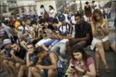  ?? DANIEL OCHOA DE OLZA — THE ASSOCIATED PRESS ?? Spanish fans play the addictive Pokemon Go game during a gathering in central Madrid, Spain, Thursday to play the computer game. In the game players try to capture, battle, and train virtual creatures in their real world locations using the GPS and...