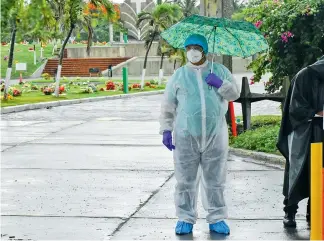  ?? JOHN ROBLEDO ?? Un hombre con traje de biosegurid­ad ingresa al cementerio Jardines de la Eternidad.