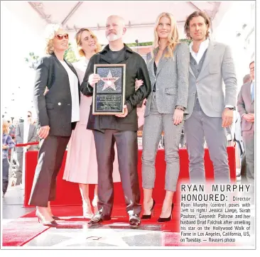  ??  ?? Ryan Murphy (centre) poses with his star on the Hollywood Walk of Fame in Los Angeles, California, US,