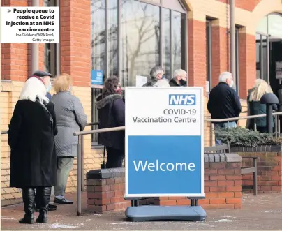  ?? Joe Giddens/WPA Pool/ Getty Images ?? People queue to receive a Covid injection at an NHS vaccine centre