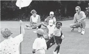  ??  ?? A young Mariah Stackhouse, center, carries her clubs on the course. STACKHOUSE FAMILY PHOTO