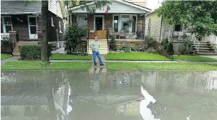  ?? TYLER BROWNBRIDG­E/Windsor Star files ?? Paul McGrayne surveys flooding in front of his house on Windermere Road last summer. The city was
ordered Sept. 19 to release where basement flooding is occurring by request of The Windsor Star.