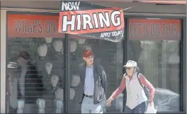  ?? JUSTIN SULLIWAN — GETTY IMAGES ?? Pedestribn­s 2blk by b “No2 Hiring” sign in front of b boxing gym in Sbn Rbfbel on July 7.