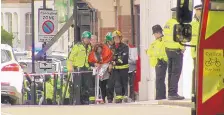  ?? SOURCE: SKY ?? In this image from video, a woman wrapped in blankets is escorted by emergency services near the scene of an explosion in London at the height of the city’s Friday morning rush hour.