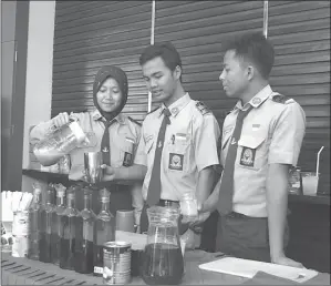  ?? EDI SUSILO/JAWA POS ?? PIAWAI: Dari kiri, Dyah Ayu Mustika, Januarz Abdul, dan Ainul Rofik meracik minuman. Para siswa SMA Hang Tuah 1 itu mengikuti pameran SMA swasta se-Jatim di Hotel Mercure kemarin (14/11).