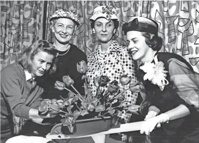  ?? THE COMMERCIAL APPEAL FILES ?? CITY BEAUTIFIER­S AT WORK - Mrs. Allan Fisher (Left) put last-minute touches on table decoration­s for a luncheon on 9 Apr 1959 at the Peabody honoring candidates for the Miss City Beautiful title. Looking on were (From Left) Mrs. Allan Redd and Mrs....