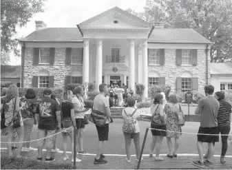  ?? THE ASSOCIATED PRESS ?? Fans wait in line outside Graceland, Elvis Presley’s former home in Memphis, Tennessee, on Tuesday.