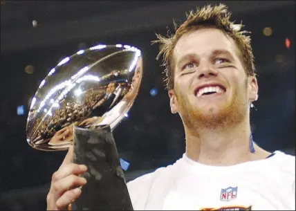  ?? DAVE MARTIN / AP FILE (2004) ?? New England Patriots quarterbac­k Tom Brady holds the Vince Lombardi Trophy after the Patriots beat the Carolina Panthers 32-29 in Super Bowl 38, Feb. 1, 2004, in Houston. Brady, who won a record seven Super Bowls for New England and Tampa Bay, has announced his retirement Wednesday. He did the same a year earlier, but came back to play another season. This time, the future Hall of Famer says, he means it.