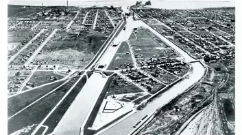  ?? PHOTO COURTESY ROBERT W. SEARS ?? Aerial view looking south at the Welland Ship Canal in Port Colborne. The curving channel on the right ( to the west) is the former channel of the third canal, within which was built the controllin­g weir where Richard Macalliste­r lost his life in 1930.