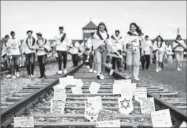  ?? Wojtek Radwanski AFP/Getty Images ?? PLAQUES with messages on a railtrack leading to the former Auschwitz-Birkenau Nazi death camp near Oswiecim, Poland, on Monday honor Holocaust victims.