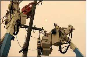  ?? AP/RICH PEDRONCELL­I ?? Pacific Gas and Electric Co. crews work last November to restore power lines in Paradise, Calif., after one of the utility’s power lines ignited a wildfire that ravaged the town.
