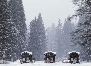  ?? Tracy Barbutes/Special to The Chronicle ?? A park ranger vehicle sits near the Big Oak Flat entrance into Yosemite National Park along Highway 120. The park is closed indefinite­ly after record snow blanketed California. On Tuesday, Yosemite Valley counted 40 inches of snow on the ground.