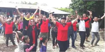  ??  ?? Participan­ts follow the instructor’s moves during the mass aerobics session.