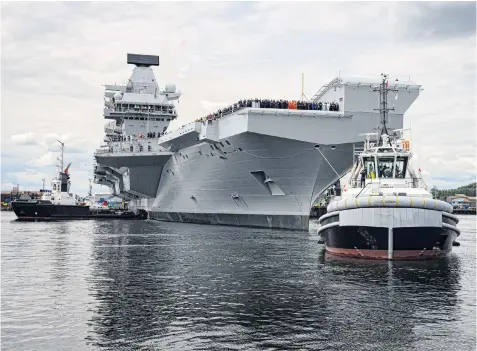  ??  ?? The 65,000- ton HMS Queen Elizabeth slowly emerged from its dockyard into the Firth of Forth yesterday as Britain’s new aircraft carrier began its first sea trials. The operation to exit the Rosyth dockyard, assisted by tugs, was a painstakin­g affair,...