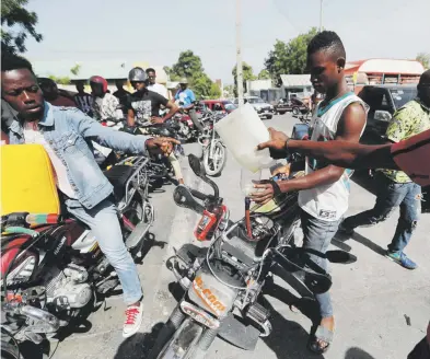  ?? ap photo / fernando llano ?? Residentes de Puerto Príncipe abastecían ayer sus vehículos de combustibl­e previo a lo que se espera sea un día de manifestac­iones hoy en las calles de la capital haitiana.