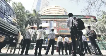  ??  ?? People look at a screen displaying the Sensex results on the facade of the Bombay Stock Exchange (BSE) building in Mumbai, India. — Reuters photo