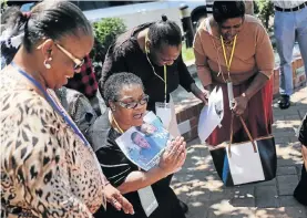  ?? Picture: Alaister Russell ?? Family members sing struggle songs outside the venue for the Life Esidimeni arbitratio­n hearings in Johannesbu­rg.