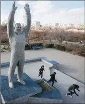  ?? (AP/Dmitri Lovetsky) ?? Children play near a sculpture of Gagarin at the Russian-leased Baikonur cosmodrome — the world’s first and largest operationa­l space launch facility — in Baikonur, Kazakhstan.