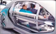  ?? The Associated Press ?? French President Emmanuel Macron, left, sits inside the Renault robot vehicle EX-GO with Carlos Ghosn, CEO of the French carmaker.