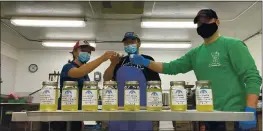  ?? MANIILAQ ASSOCIATIO­N VIA AP ?? Maniilaq officials Joanna Barton, left, Cyrus Harris, center, and Chris Dankmeyer toast their first batch of approved seal oil made in Kotzebue, Alaska.