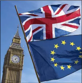  ??  ?? An EU flag and a Union flag held by a demonstrat­or are seen with Elizabeth Tower (Big Ben) as marchers take part in an anti-Brexit, pro-European Union rally in London on Tuesday.