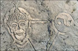  ?? Bizuayehu Tesfaye Las Vegas Review-journal @btesfaye ?? Rocks arranged by an unknown person in the shape of a large triangle with a yin yang at one point and a face at the other as seen from above in the southwest Las Vegas Valley on Jan. 19.