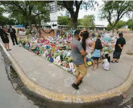  ?? ERIC GAY/AP ?? Mourners visit a memorial Friday at Robb Elementary School in Uvalde, Texas, honoring the victims of the May 24 attack that left 19 students and two teachers dead.