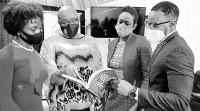  ??  ?? Audrey Hinchcliff­e (centre) shows her new book ‘The Will to Overcome, Reflection­s on Circumstan­ce, Vision, Service’ to (from left) Business Developmen­t Coordinato­r, University Hospital of the West Indies Private Wing, Jannielle Morgan; President and CEO of First Global Bank, Mariame McIntosh Robinson; and Learning and Developmen­t Officer, Sagicor Life Jamaica Limited, Jason Brown.