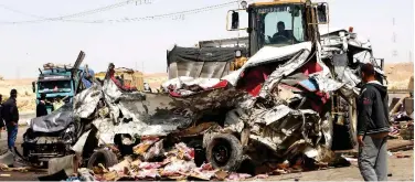  ?? Agence France-presse ?? ↑ Workers remove the wreckage of a car at the site of a road accident in El Saff on Thursday.