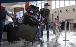  ?? ALYSSA POINTER — THE NEW YORK TIMES ?? Travelers walk through the Hartsfield-Jackson Atlanta Internatio­nal Airport in Atlanta earlier this year.