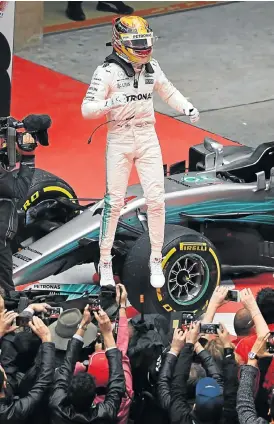  ?? /AFP ?? Centre of attention: Lewis Hamilton jumps from his car after winning the Chinese Grand Prix in Shanghai on Sunday to the delight of the media and fans.