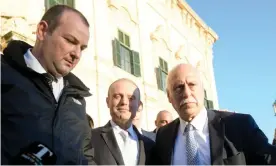  ??  ?? Malta’s prime minister, Joseph Muscat, centre, is shielded by bodyguards after leaving a cabinet meeting on Tuesday. Photograph: Matthew Mirabelli/AFP via Getty Images