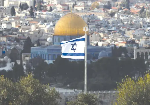  ?? (Ammar Awad/Reuters) ?? AN ISRAELI flag with a Magen David on top of it appears in the foreground of the Dome of the Rock in Jerusalem’s Old City.