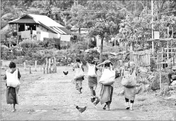  ??  ?? Villagers returning from a day working in nearby fields in Kongthong village.