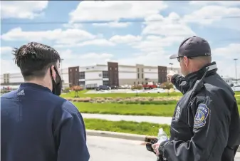  ?? Jon Cherry / Getty Images ?? A FedEx employee speaks with a police officer about about the deadly shootings at a FedEx facility in Indianapol­is. The 19yearold gunman killed himself immediatel­y after the attack.