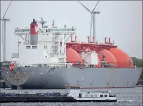  ?? Bloomberg/JASPER JUINEN ?? The Arctic Discoverer liquefied natural gas (LNG) tanker, operated by K Line LNG Shipping UK Ltd., sits moored at the Gate LNG terminal as wind turbines stand beyond in the Port of Rotterdam in Rotterdam, Netherland­s, in June.