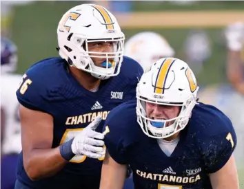  ?? STAFF FILE PHOTO BY C.B. SCHMELTER ?? UTC left tackle Malcolm White, left, helps quarterbac­k Nick Tiano up during a home game against Western Carolina last September. White is one of four returning starters on the offensive line.