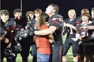  ?? ?? Overcome with emotion, Danielle Martinez buried her head in the shoulder of her fiance, Justin Blount, as fellow Blackhawk football team members cheered Blount’s proposal Friday, Sept. 24, after the home football game. Blount surprised Martinez with the proposal. Martinez thought she was joining the group for a photograph with their son, Austin Blake Blount, born Dec. 7, 2020.