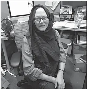 ??  ?? Nancy Allen, shown at her desk at the Faulkner County Library, wears a hijab in support of Muslim women. A hijab is a head covering worn by many Muslim women as a sign of modesty.