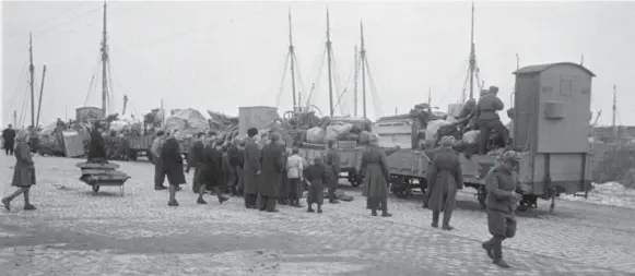  ??  ?? Efter knap et års besaettels­e af Bornholm meddelte Sovjetunio­nen midt i marts 1946, at de russiske befrielses­styrker ville forlade øen inden for 2-3 uger. Den 5. april forlod den sidste sovjetruss­iske soldat øen. Her er russiske soldater i faerd med at udlosse materiel fra godsvogne til afskibning fra Nexø. Foto: Tage Christense­n