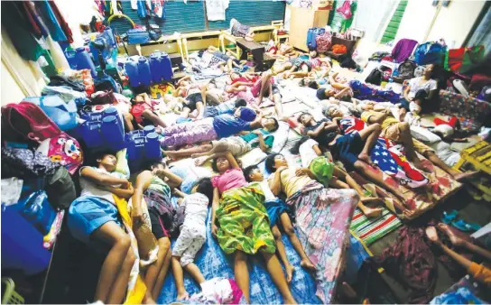  ?? (Czar Dancel) ?? EVACUEES find sleep in every conceivabl­e space inside one of the classrooms used as evacuation centers for families displaced by Mayon Volcano’s continued activity.