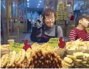  ??  ?? This woman sells di erent kinds of Korean delicacies.