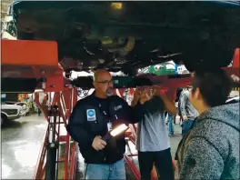  ?? CONTRIBUTE­D ?? Instructor Matthew Svoboda works with students at Santa Cruz High School auto shop.