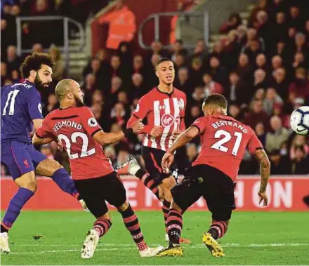  ??  ?? Mohamed Salah (left) shoots past Southampto­n players to score Liverpool’s second goal at St Mary’s Stadium on Friday.